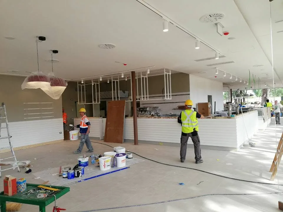 Cantiere di interni con squadre al lavoro durante la fase di finitura